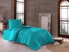 A bedroom scene with a bed made with turquoise bedding, a mirror, and a window overlooking a landscape. Produktbild-Vorschau