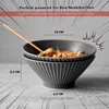 Two ceramic bowls, one stacked on top of the other, with chopsticks resting on the top bowl. Dimensions and capacity are indicated with text overlays. Produktbild-Vorschau