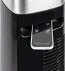 Close-up of a black tower fan with a silver top, showing the control panel and a remote control inserted into a slot. Voir les images du produit