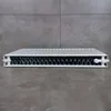 A white radiator is placed on a gray tiled floor in front of a gray tiled wall. Produktbild-Vorschau
