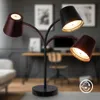 A multi-headed LED desk lamp is shown in a home office setting, with a desk and chair blurred in the background. Náhľad obrázku produktu
