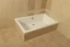 A white bathtub is installed in a bathroom with beige tiles on the walls and floor. Produktbild-Vorschau