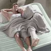 A couple lying on an air mattress, covered by a blanket. Podgląd zdjęcia produktu