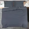 A neatly made bed with a dark gray duvet cover and two pillows. Náhľad obrázku produktu