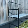 A black metal folding scaffold with a white platform is shown against a wooden wall. Anteprima dell’immagine prodotto