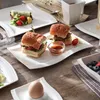 A table setting with various dishes, including sandwiches, a wrap, and an egg. Náhled obrázku produktu