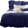 A close-up view of a navy blue duvet cover and pillows on a bed. Produktbild-Vorschau
