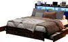 A bed with a headboard featuring LED lighting and storage, shown with drawers pulled out. Produktbild-Vorschau