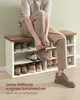 A person is sitting on a shoe bench and putting on shoes. The shoe bench has multiple shelves filled with shoes. Produktbild-Vorschau