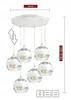 A multi-pendant light fixture with six glass globes hanging from a circular ceiling mount. Produktbild-Vorschau