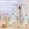 A young girl is using a gymnastics bar in a room with children's furniture and toys. Voir les images du produit