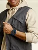 A man wearing a vest and hoodie, showing off his watch. Produktbild-Vorschau
