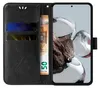 A black flip cover phone case with floral and butterfly embossing, showing credit cards and a banknote inserted into the card slots, and a smartphone displayed within the case. Produktbild-Vorschau