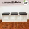 A white Kallax shelf unit with three dark gray cushions on top, placed on a wooden floor. Anteprima dell’immagine prodotto