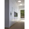 A modern kitchen with white cabinets and built-in appliances, with a large window overlooking a garden. Produktbild-Vorschau