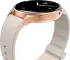 A close-up side view of a smartwatch with a gold-colored casing and a white strap. Voir les images du produit