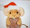 A plush toy mouse wearing a Santa hat and holding a gingerbread cookie. Produktbild-Vorschau