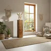 A cozy living room scene with a wooden decorative column, plants, and a window overlooking a garden. Voir les images du produit
