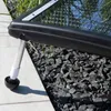A close-up of a solar collector's leg and base, resting on a tiled patio and gravel. Podgląd zdjęcia produktu