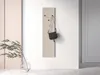 A handbag hanging on a wall-mounted coat rack next to a plant in a vase. Produktbild-Vorschau