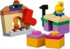 A collection of LEGO® Friends building blocks arranged to form a fireplace with a stocking, a workbench with a duck, and two gift boxes. Náhled obrázku produktu