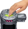A hand is pressing down on a neon green button on a gray toy. Náhľad obrázku produktu