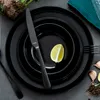 A set of black ceramic plates with a knife and a slice of lime on top. Náhled obrázku produktu