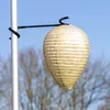 A paper lantern shaped like a wasp nest hangs from a pole. Produktbild-Vorschau