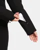 A person's hand is shown inserting a card into a zippered pocket on the sleeve of a black jacket. Produktbild-Vorschau