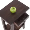 A green apple on a dark brown wooden end table with a drawer. Produktbild-Vorschau