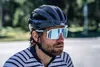 A man wearing a black bicycle helmet and white sunglasses, looking to the side. Anteprima dell’immagine prodotto