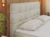 A close-up view of a beige upholstered bed with two decorative pillows on top of the mattress. Produktbild-Vorschau