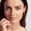 Close-up of a woman's face and upper chest, showing her wearing earrings. Produktbild-Vorschau