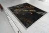 A close-up, angled view of a black and gold marble cutting board inset into a light gray speckled countertop. Náhľad obrázku produktu