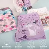 A collection of girls' underwear with various patterns and cartoon prints, displayed on a light blue and white surface. Produktbild-Vorschau