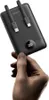 A hand holds a black power bank with integrated cables and a digital display. Produktbild-Vorschau
