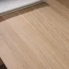 A close-up view of a wooden surface, likely a desk, with a book or binder resting on the top left edge. Produktbild-Vorschau