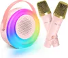 A pink karaoke machine with a colorful LED ring and two pink microphones with gold mesh grills are displayed against a white background. Náhľad obrázku produktu
