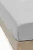 A close-up view of a gray fitted sheet on a bed. Podgląd zdjęcia produktu