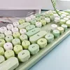 A close-up view of a green and white keyboard with round keys. Náhled obrázku produktu