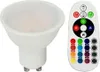 A white LED light bulb and a white remote control with colorful buttons are shown against a white background. Produktbild-Vorschau