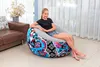 A young girl sits on an inflatable chair in a living room. Produktbild-Vorschau