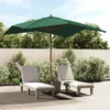 Two lounge chairs and a large green umbrella are set up on a patio with a wooden fence and lush greenery in the background. Náhled obrázku produktu