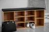 A shoe bench with storage compartments in a hallway, featuring a black cushion and a black handbag next to it. Náhled obrázku produktu