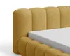 Close-up of a yellow upholstered bed frame with a white mattress. Voir les images du produit