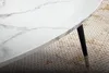 A close-up of a marble-look tabletop with a black leg and gold accent. Voir les images du produit