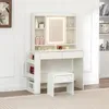 A white vanity table with a lighted mirror and a stool, set against a white wall. Produktbild-Vorschau