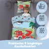 A young boy sleeping on a bed with children's bedding featuring a fire truck and helicopter motif. Informational icons are displayed on the right side. Produktbild-Vorschau