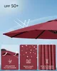 A close-up of a red umbrella canopy with graphics and text highlighting its features. Produktbild-Vorschau