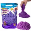 A bag of purple kinetic sand is shown next to a hand holding and manipulating the sand, and a pile of the sand. Voir les images du produit